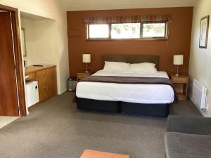 a bedroom with a large bed and a window at Hanmer Garden Suites in Hanmer Springs