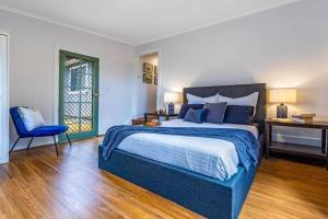 1 dormitorio con cama, escritorio y silla en LUXMI - "New to Booking", en Katoomba