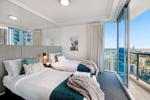 2 camas en una habitación de hotel con ventana grande en Ocean Views! 3 Bedrooms plus 2 Bathrooms - Chevron Renaissance - Wow Stay, en Gold Coast