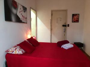 a red bed with red pillows in a room at Aconchegante Lapa in Rio de Janeiro