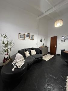 sala de estar con sofá negro y mesa en El Garaje en Puerto Deseado
