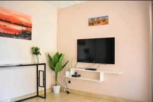 a living room with a flat screen tv on a wall at House of Joy in Lilongwe
