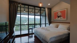 um quarto com uma cama e uma grande janela em Gustavia House and Mountain em Ban Nong Rang Chang