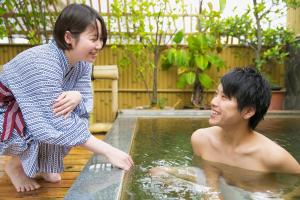 um rapaz e uma rapariga a brincar numa piscina em Hotel Koraku em Beppu