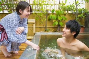 a boy and a girl playing in a swimming pool at Hotel Koraku in Beppu