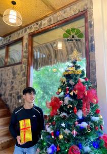 a man standing in front of a christmas tree at Lemon Tree Homestay Tam Coc in Ninh Binh