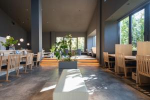 a dining room with tables and chairs and windows at The Ryokan Tokyo YUGAWARA in Yugawara