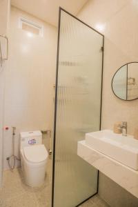 a bathroom with a toilet and a sink and a mirror at Suri Homestay in Da Lat