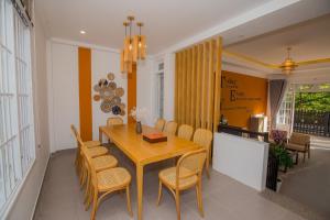 a dining room with a wooden table and chairs at Suri Homestay in Da Lat