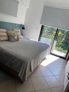 a bedroom with a bed and a large window at Beautiful newly refurbished 2 bedroom 2 Bathroom 2nd floor condo in Tamarindo