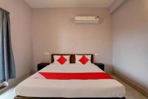 Bett mit roten Kissen in einem Zimmer in der Unterkunft OYO Flagship Casa Midland in Bhubaneshwar