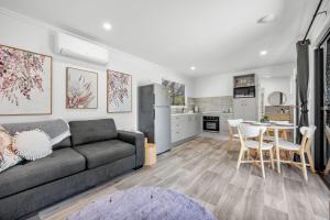 uma sala de estar com um sofá e uma mesa em Little Sunshine - Private acreage Guest Home em Hervey Bay