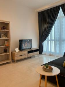 sala de estar con sofá y TV en Foo homestay @setia sky88, en Johor Bahru