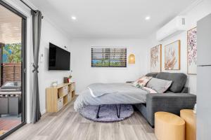 a living room with a couch and a tv at Little Sunshine - Private acreage Guest Home in Hervey Bay