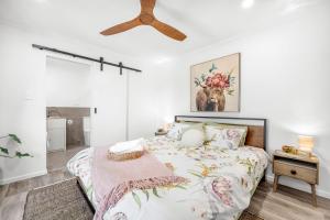 um quarto com uma cama e uma ventoinha de tecto em Little Sunshine - Private acreage Guest Home em Hervey Bay