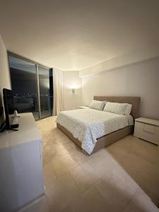 um quarto com uma cama e uma grande janela em Apartamento 5 estrellas, vista al mar na Cidade do Panamá