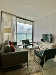 uma sala de estar com um sofá e uma televisão em Apartamento 5 estrellas, vista al mar na Cidade do Panamá