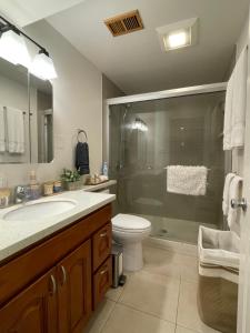 y baño con ducha, aseo y lavamanos. en 9AM Check-in Coastal Getaway - Luxe Suite near Cliff, Lake & Local Shops en Daly City
