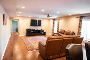 a living room with a couch and a flat screen tv at Charming Apartment on Oak in Cookeville