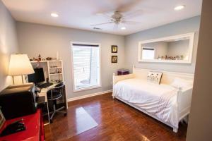 a bedroom with a bed and a desk with a computer at Charming Apartment on Oak in Cookeville
