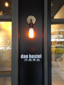 a sign on a door with a light on it at Dan Hostel丹居青旅 in Taipei