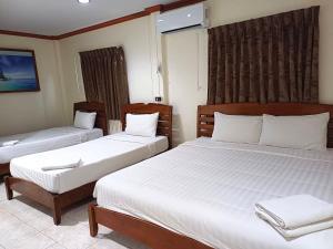 a bedroom with two beds with white sheets at Golden Bee PhiPhi in Phi Phi Don