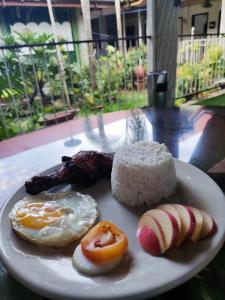a plate of food with eggs bacon and other foods at Infinite Green Pension in Puerto Princesa City