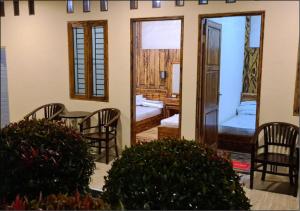 um quarto com uma mesa e cadeiras e um quarto em Omah Gunung Homestay em Batur
