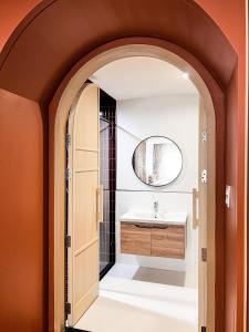 an archway leading into a bathroom with a sink at SO Zen Hotel Silom Bangkok in Bang Rak