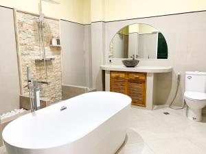 a bathroom with a sink and a toilet and a mirror at Ayodya Batur Villa in Kintamani