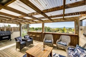 a patio with a table and chairs and a grill at Serenity by the Sea - Haumoana Beach Holiday Home in Haumoana