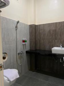 a bathroom with a shower and a sink at Genio Syariah Hotel Solo in Tjolomadu