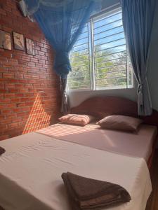 a bedroom with two beds and a window at ING ING GUESTHOUSE in Koh Rong Sanloem