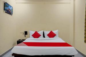 a bedroom with a large bed with red pillows at Hotel Royal Inn in Pune