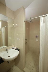 y baño con lavabo y ducha. en University Club (UC) Hotel UGM en Yogyakarta
