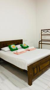 a bed with green and white pillows on it at Elisha Place Hiriketiya in Dickwella