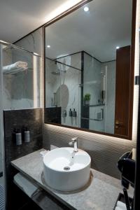 a bathroom with a sink and a glass shower at M2 Square by Monday Premium in Nagpur