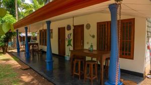 una casa con colonne blu e tavolo e sedie di Jayanti's a Sigiriya Altre 10 foto
