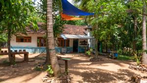 una casa con palmeras delante en Jayanti's en Sigiriya