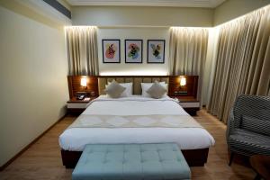 Habitación de hotel con cama y silla en M2 Square by Monday Premium, en Nagpur