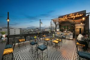 a restaurant with tables and chairs on a balcony at Amira Hotel Hanoi in Hanoi