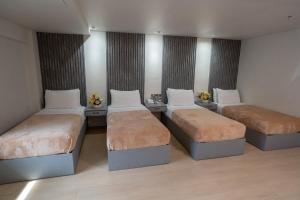 pokój z 3 łóżkami w pokoju w obiekcie Hotel Carmelita w mieście Tuguegarao