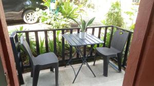 a table and chairs on a balcony with a potted plant at BOHOL Simple and Elegant Furnished Studio in Tagbilaran City