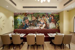 a dining room with a large painting on the wall at M2 Square by Monday Premium in Nagpur