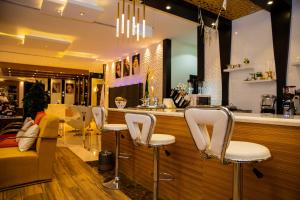 a bar with white chairs in a store at فندق الفاو بلازا in Sharurah