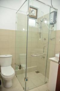 a bathroom with a toilet and a glass shower at Cozy 2 bed 1 bath Apartment for rent in Homagama