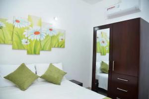 a bedroom with a white bed with green pillows at Cozy 2 bed 1 bath Apartment for rent in Homagama