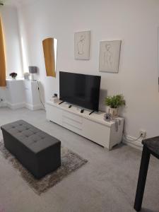 a living room with a flat screen tv on a white cabinet at Modern 2 bed house sleeps 6 in Portsmouth