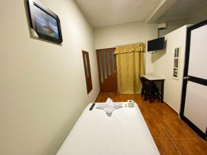 een slaapkamer met een bed en een tv aan de muur bij HOTEL BROMELIAS in Tarapoto