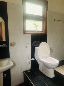 een badkamer met een wit toilet en een raam bij White Villa Ella/ Badulla in Badulla